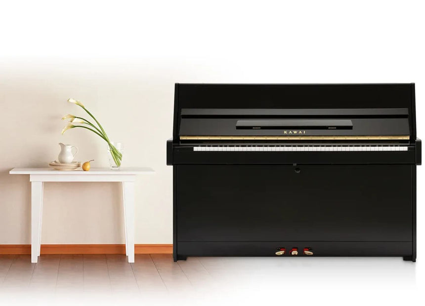 Piano droit Kawai K-15 E noir brillant – vue de face dans une pièce.