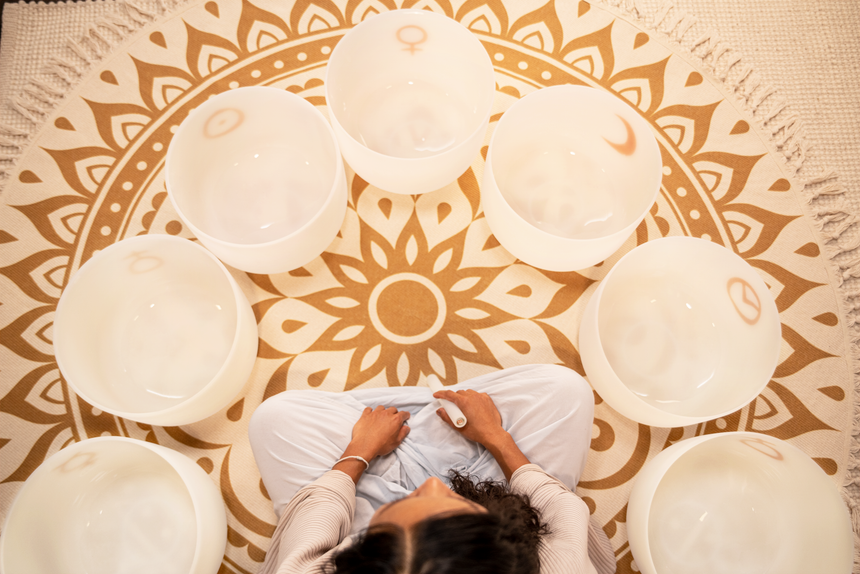 MEINL PCSBSETCHA set of seven white-frosted crystal singing bowls with gold planetary symbols – overhead view of seven singing bowls arranged in a circle.