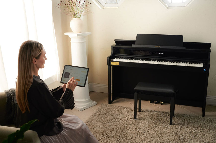 Casio AP-750BK digital piano in black – living-room scene with the music app being controlled on a tablet.