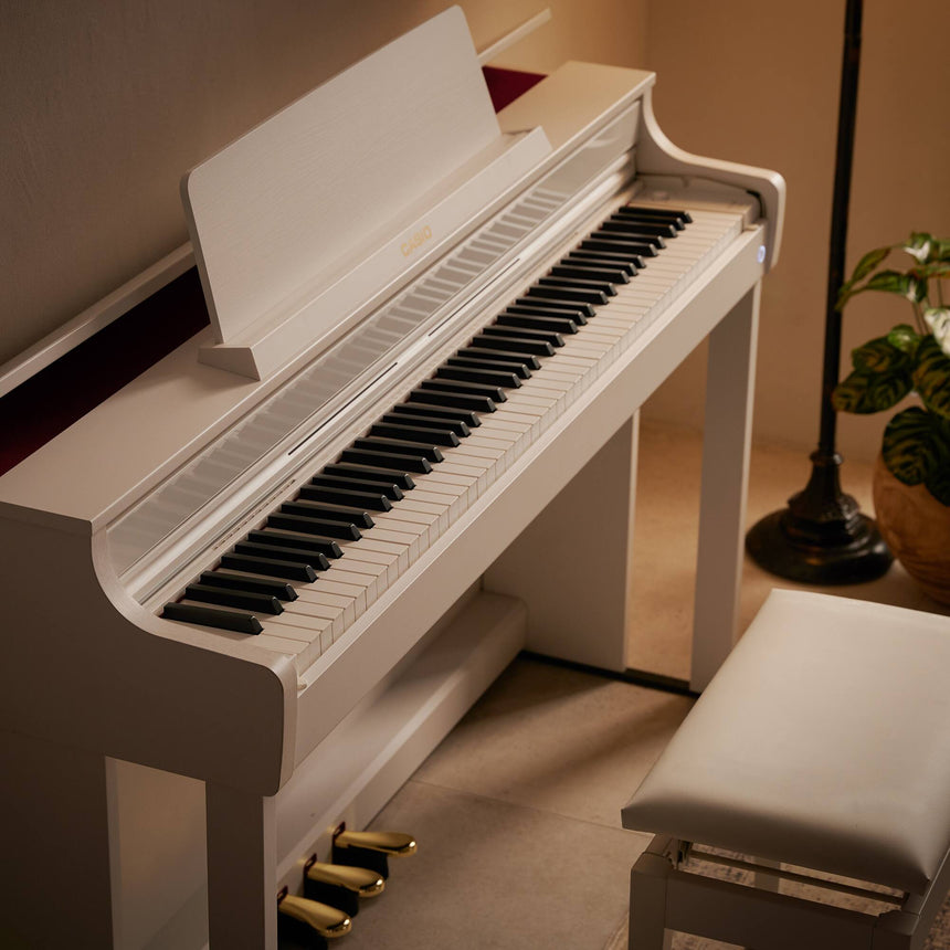 Piano numérique Casio AP-550WE blanc – vue rapprochée de côté du clavier et du meuble.