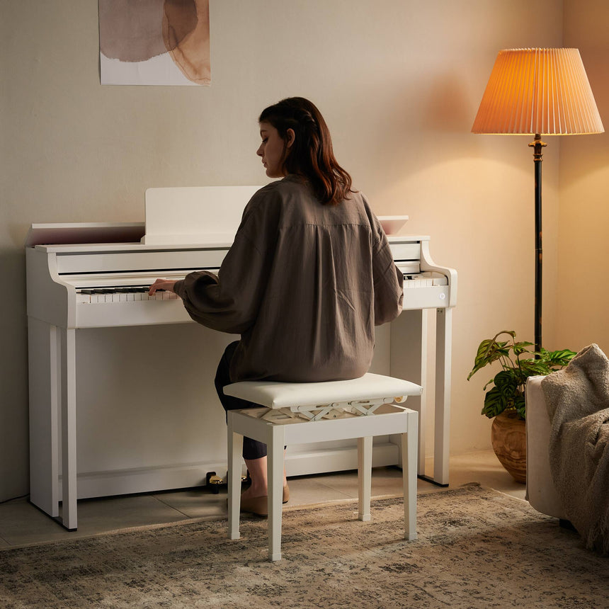 Piano numérique Casio AP-550WE blanc – scène dans un salon avec pianiste.