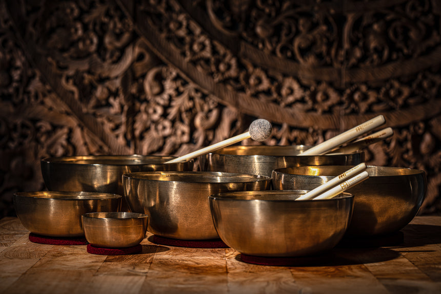MEINL SB-SET-CHA set of seven singing bowls in bronze alloy – view of the set on a wooden surface against a dark background.
